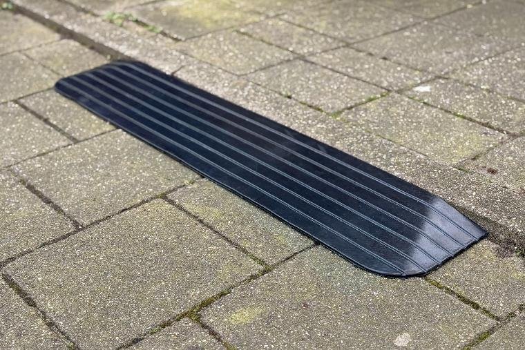 zwarte rubberen drempelhulp buiten liggend tegen een drempel aan